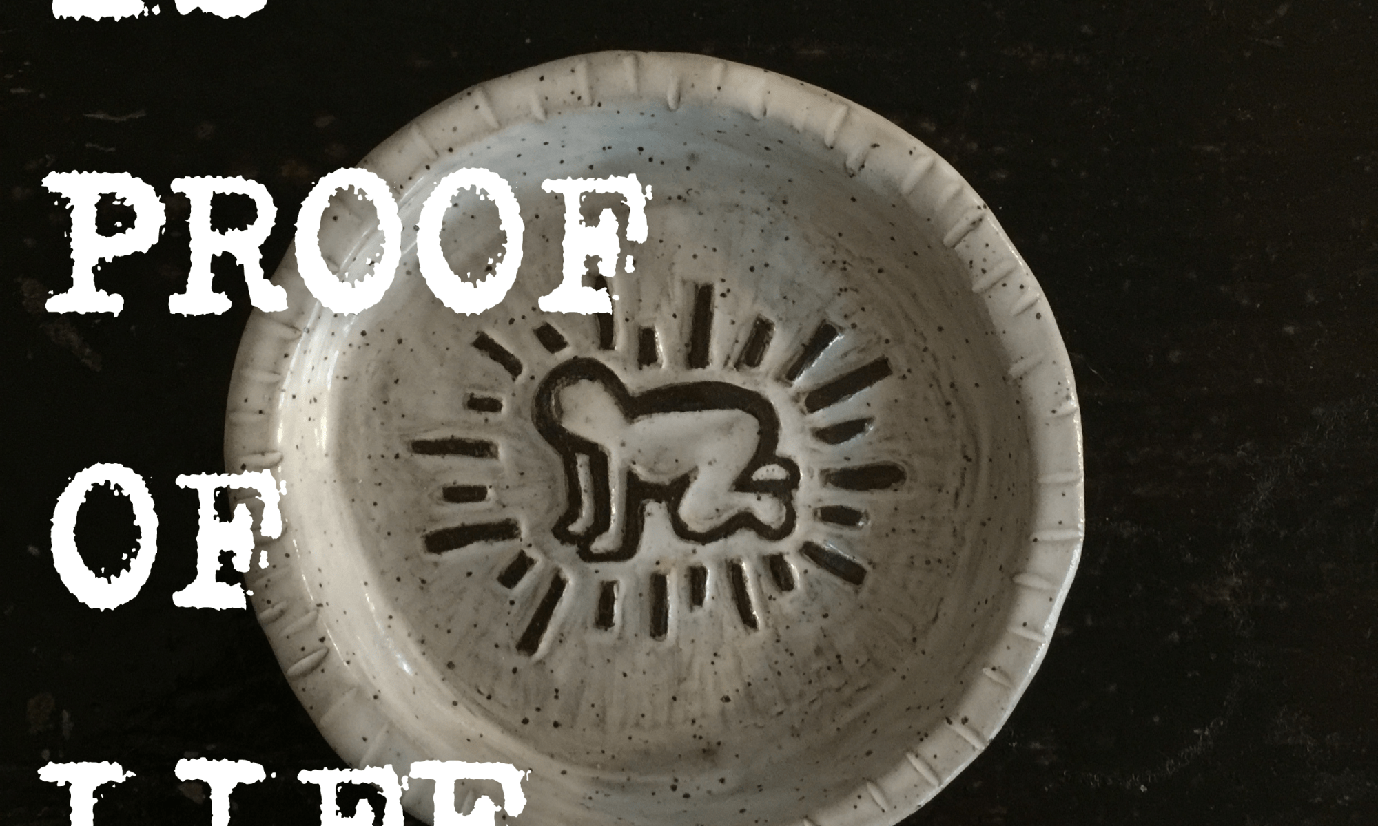 A white round shallow ceramic dish is carved on the flat base with a black outline of a person on their hands and knees with lines creating a circle around them. the imagery was directly taken from the artist Keith Haring and carved into this piece by Evan Devovere as tribute to his work and their affinity for it. On the side of the image is text which reads: DEBT IS PROOF OF LIFE LIVED